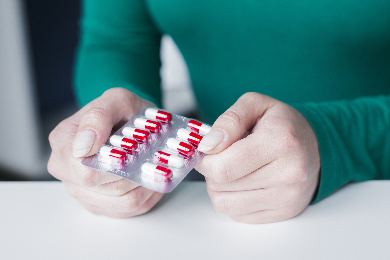 epilare-definitiva-tratament-antibiotice Pacientă ținând un blister cu antibiotice înainte de epilarea definitivă